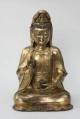 Bodhisattwa Guanyin - ujęcie z przodu; Duża, wykonana ze złoconego brązu figura przedstawia siedzącą w pozie medytacyjnej kobietę Bodhisattwę Guanyin (chin. 观音, sanskr. Awalokiteśwara, tyb. Czenrezig). Postać ma spuszczone, przymknięte oczy, symetryczną, pełną twarz o pogodnym i spokojnym wyrazie oraz gładko zaczesane włosy, schowane pod diademem i zaciągniętą na głowę tkaniną. Ubrana jest w długie, warstwowe, jedwabne szaty królewskie oraz wyszukaną, ciężką biżuterię książęcą: diadem, w którego centrum znajduje się niebiański Budda Amitabha (sanskr. Amitābha); pary dużych, okrągłych kolczyków ze spiczastymi zawieszkami oraz grubego naszyjnika z klejnotem, od którego odchodzi siedem pasów korali z wisiorkami. Jej prawa dłoń uniesiona na wysokości klatki piersiowej ułożona jest pionowo, jej środkowy palec i kciuk tworzą okrąg trzymając niezidentyfikowany, haczykowaty przedmiot. Poniżej znajduje się ustawiona poziomo lewa dłoń, która ściska niewielką wazę.