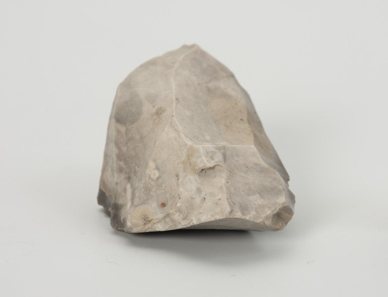 rdzeń wielopiętowy - Ujęcie z boku; Rdzeń wielopiętowy w formie wydłużonego klina z widocznymi kilkoma miejscami, z których odbijano wióry. Strategia redukcji typowa dla rdzeni w ostatnim stadium użytkowania, szczególnie na stanowiskach bez źródeł surowca dobrej jakości w pobliżu. Ślady eksploatacji miękkim tłukiem. Bryła jasnoszarego krzemienia kredowego bardzo dobrej jakości.