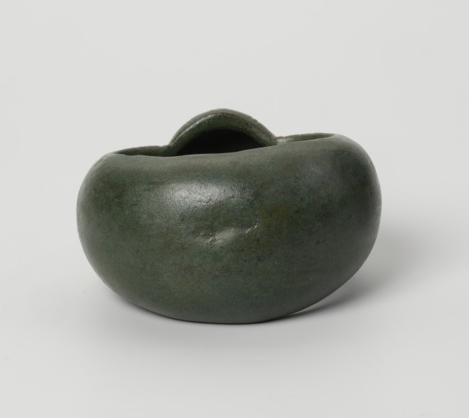 kopia bransolety nerkowatej z Kolkowa - Ujęcie z tyłu; Bransoleta o szerokiej obręczy (5,9 cm), silnie wypukła. Bransoleta ma zielony kolor.