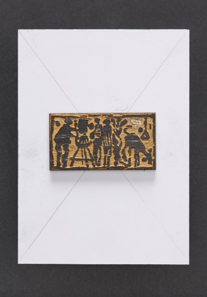 klocek drzeworytniczy - Klocek drewniany, z wyrytym tłem tworzącym wypukłą powierzchnie odbicia matrycy przedstawiającą malarza przy sztaludze po prawej stronie, dwie postacie oraz zwierzę po stronie lewej klocka drzeworytniczego. Matryca przymocowana do prostokątnego kawałka płyty wiórowej z naklejonym od przodu białym laminatem oraz szarą tekturą od tyłu.