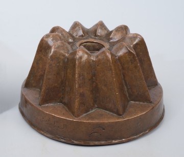 ujęcie 3/4. Naczynie stożkowate, z kominem. Na prostym cokole dziesięć trójkątnych, ostro zakończonych pukli.