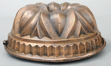 strona trzecia. Dolna partia naczynia złożona z dekoracji o formie ostrosłupów. Po lewej widoczny zaczep bez kółka do zawieszenia.