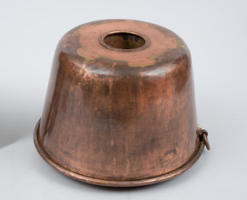 ujęcie 3/4 z góry. Naczynie w kształcie lekko zwężającego się u góry walca, z wgłębieniem w kształcie tulei pośrodku.