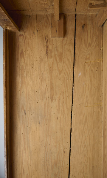 szafa - Szafa drewniana, dwudrzwiowa, w kolorze brązowym (kolor naturalnego drewna). Obiekt został z zewnątrz zabezpieczony lakierem. U dołu szafy widoczne dwie szuflady zamykane na klucz (brak kluczy; brak okucia zamka prawej szuflady). Wewnątrz, na tylnej ścianie, w jej górnej części umieszonych zostało siedem drewnianych wieszaków. W połowie wysokości zwieńczenia szafy widoczna pozioma listwa (ubytek listowy na prawej ścianie). Płyciny drzwi wykonane są z desek. Obiekt jest pozbawiony zdobień. Od spodu, w narożnikach szafy umieszczone zostały cztery podtrzymujące obiekt nogi wykonane z fragmentów deski i pomalowane żółto-brązową farbą olejną.W wnętrzu szafy, na tylnej ścianie oraz ścianach bocznych widoczne napisy oraz rysunki wykonane odręcznie ołówkiem. Na lewej ścianie widoczny napis: „Ta szafa była moi mieszkaniem ukrywalnym dn 21 II 43 r do dnia 25 IIII 43 r”, wizerunek nagiej kobiety stojącej bokiem i trzymającej ręce na kroczu (zasłaniającej się) oraz kobiety w kostiumie, której twarz jest ujęta z profilu, a jedna z nóg uniesiona do góry. Jej włosy są ułożone w fale. Pod nagą kobietą widniej podpis ,,(Głupia baba)’’. Nad kobietą w kostiumie napisano ,,(Francóska niewiasta)’’. Obok nagiej kobiety widoczna jest kolejna data: ,,20.1.43 r.’’.
Na tylnej ścianie widoczne są przedstawienia (od lewej strony): budynku mieszkalnego (domu jednorodzinnego),  wiatraka (pod nim), kobiety w spódnicy za kolano i kamizelce stojącej bokiem (obok, z prawej strony rysunku wiatraka), trzech postaci umieszczonych jedna pod drugą, niewielkiego samochodu (obok, z prawej strony postaci), drogowskazu (obok, z prawej strony samochodu), mężczyzny z długą brodą (Żyda; pod nim) ciągnącego za sobą konia oraz niedokończonej nagiej postaci przedstawionej tyłem (widoczne pośladki; pod rysunkiem konia).
Obok przedstawienia kobiety widoczny napis: ,,Hiszpańska dziewczyna’’. Pod spodem widoczny napis ,,Pffeferwehrtag | Przygody Tomcia | paluszki’’. Obok trzech postaci (ułożonych w linii jedna pod drugą) napis ,,(kąpiel)’’. Na drogowskazie napis ,,Do Palestyny 3814 km’’. Obok mężczyzny z brodą widoczny napis wersalikami „HIR, JUDE, DI, AŁH, JUDE’’.
Na prawej ścianie szafy widoczne przedstawienie zbliżenia cielesnego (dwóch nagich postaci połączonych ze sobą w uścisku), które zostało częściowo starte.
Wszystkie rysunki widoczne na ścianach bocznych zostały wykonane z boku zwrócone są górą do tylnej ściany obiektu. Rysunki widoczne na tylnej ścianie obiektu usytuowane są do góry nogami (odwrócone o 180° w stosunku do dna szafy).