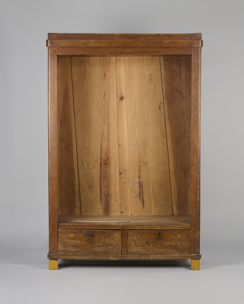 Szafa drewniana, dwudrzwiowa, w kolorze brązowym (kolor naturalnego drewna). Obiekt został z zewnątrz zabezpieczony lakierem. U dołu szafy widoczne dwie szuflady zamykane na klucz (brak kluczy; brak okucia zamka prawej szuflady). Wewnątrz, na tylnej ścianie, w jej górnej części umieszonych zostało siedem drewnianych wieszaków. W połowie wysokości zwieńczenia szafy widoczna pozioma listwa (ubytek listowy na prawej ścianie). Płyciny drzwi wykonane są z desek. Obiekt jest pozbawiony zdobień. Od spodu, w narożnikach szafy umieszczone zostały cztery podtrzymujące obiekt nogi wykonane z fragmentów deski i pomalowane żółto-brązową farbą olejną.W wnętrzu szafy, na tylnej ścianie oraz ścianach bocznych widoczne napisy oraz rysunki wykonane odręcznie ołówkiem. Na lewej ścianie widoczny napis: „Ta szafa była moi mieszkaniem ukrywalnym dn 21 II 43 r do dnia 25 IIII 43 r”, wizerunek nagiej kobiety stojącej bokiem i trzymającej ręce na kroczu (zasłaniającej się) oraz kobiety w kostiumie, której twarz jest ujęta z profilu, a jedna z nóg uniesiona do góry. Jej włosy są ułożone w fale. Pod nagą kobietą widniej podpis ,,(Głupia baba)’’. Nad kobietą w kostiumie napisano ,,(Francóska niewiasta)’’. Obok nagiej kobiety widoczna jest kolejna data: ,,20.1.43 r.’’.
Na tylnej ścianie widoczne są przedstawienia (od lewej strony): budynku mieszkalnego (domu jednorodzinnego),  wiatraka (pod nim), kobiety w spódnicy za kolano i kamizelce stojącej bokiem (obok, z prawej strony rysunku wiatraka), trzech postaci umieszczonych jedna pod drugą, niewielkiego samochodu (obok, z prawej strony postaci), drogowskazu (obok, z prawej strony samochodu), mężczyzny z długą brodą (Żyda; pod nim) ciągnącego za sobą konia oraz niedokończonej nagiej postaci przedstawionej tyłem (widoczne pośladki; pod rysunkiem konia).
Obok przedstawienia kobiety widoczny napis: ,,Hiszpańska dziewczyna’’. Pod spodem widoczny napis ,,Pffeferwehrtag | Przygody Tomcia | paluszki’’. Obok trzech postaci (ułożonych w linii jedna pod drugą) napis ,,(kąpiel)’’. Na drogowskazie napis ,,Do Palestyny 3814 km’’. Obok mężczyzny z brodą widoczny napis wersalikami „HIR, JUDE, DI, AŁH, JUDE’’.
Na prawej ścianie szafy widoczne przedstawienie zbliżenia cielesnego (dwóch nagich postaci połączonych ze sobą w uścisku), które zostało częściowo starte.
Wszystkie rysunki widoczne na ścianach bocznych zostały wykonane z boku zwrócone są górą do tylnej ściany obiektu. Rysunki widoczne na tylnej ścianie obiektu usytuowane są do góry nogami (odwrócone o 180° w stosunku do dna szafy).