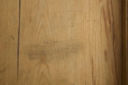 szafa - Szafa drewniana, dwudrzwiowa, w kolorze brązowym (kolor naturalnego drewna). Obiekt został z zewnątrz zabezpieczony lakierem. U dołu szafy widoczne dwie szuflady zamykane na klucz (brak kluczy; brak okucia zamka prawej szuflady). Wewnątrz, na tylnej ścianie, w jej górnej części umieszonych zostało siedem drewnianych wieszaków. W połowie wysokości zwieńczenia szafy widoczna pozioma listwa (ubytek listowy na prawej ścianie). Płyciny drzwi wykonane są z desek. Obiekt jest pozbawiony zdobień. Od spodu, w narożnikach szafy umieszczone zostały cztery podtrzymujące obiekt nogi wykonane z fragmentów deski i pomalowane żółto-brązową farbą olejną.W wnętrzu szafy, na tylnej ścianie oraz ścianach bocznych widoczne napisy oraz rysunki wykonane odręcznie ołówkiem. Na lewej ścianie widoczny napis: „Ta szafa była moi mieszkaniem ukrywalnym dn 21 II 43 r do dnia 25 IIII 43 r”, wizerunek nagiej kobiety stojącej bokiem i trzymającej ręce na kroczu (zasłaniającej się) oraz kobiety w kostiumie, której twarz jest ujęta z profilu, a jedna z nóg uniesiona do góry. Jej włosy są ułożone w fale. Pod nagą kobietą widniej podpis ,,(Głupia baba)’’. Nad kobietą w kostiumie napisano ,,(Francóska niewiasta)’’. Obok nagiej kobiety widoczna jest kolejna data: ,,20.1.43 r.’’.
Na tylnej ścianie widoczne są przedstawienia (od lewej strony): budynku mieszkalnego (domu jednorodzinnego),  wiatraka (pod nim), kobiety w spódnicy za kolano i kamizelce stojącej bokiem (obok, z prawej strony rysunku wiatraka), trzech postaci umieszczonych jedna pod drugą, niewielkiego samochodu (obok, z prawej strony postaci), drogowskazu (obok, z prawej strony samochodu), mężczyzny z długą brodą (Żyda; pod nim) ciągnącego za sobą konia oraz niedokończonej nagiej postaci przedstawionej tyłem (widoczne pośladki; pod rysunkiem konia).
Obok przedstawienia kobiety widoczny napis: ,,Hiszpańska dziewczyna’’. Pod spodem widoczny napis ,,Pffeferwehrtag | Przygody Tomcia | paluszki’’. Obok trzech postaci (ułożonych w linii jedna pod drugą) napis ,,(kąpiel)’’. Na drogowskazie napis ,,Do Palestyny 3814 km’’. Obok mężczyzny z brodą widoczny napis wersalikami „HIR, JUDE, DI, AŁH, JUDE’’.
Na prawej ścianie szafy widoczne przedstawienie zbliżenia cielesnego (dwóch nagich postaci połączonych ze sobą w uścisku), które zostało częściowo starte.
Wszystkie rysunki widoczne na ścianach bocznych zostały wykonane z boku zwrócone są górą do tylnej ściany obiektu. Rysunki widoczne na tylnej ścianie obiektu usytuowane są do góry nogami (odwrócone o 180° w stosunku do dna szafy).