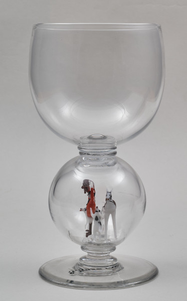 ﻿Kielich w typie „Römer”. Posiada półkolistą czaszę z cylindrycznym zwężeniem u góry. Charakterystyczny jest nodus w kształcie kuli. Kielich zakończony jest okrągłą, gładką stopą. Stopa i czara połączone są z nodusem pierścieniami. W nodus wtopiona jest scena myśliwska.