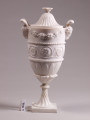Wazon w stylu klasycystycznym z uchwytem w kształcie głów baranów. Pokrywka dzwonowata.