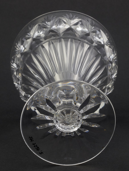 Kieliszek okrągły, ozdobiono szlifowaną dekoracją rośliną. Stopa okrągła, nóżka krótka i szeroka, zakończona pierścieniem, na którym osadzona stożkowata czara. Spód stopy dekorowany płytkim szlifem o motywie wielopłatkowego kwiatka.