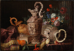 Na blacie zgromadzone wytworne przedmioty: trzy repusowane dzbany w centrum, w ich pobliżu srebrna kasetka i zegarek na czerwonej wstążce. Utensylia przykrywają brunatno-malinową draperię z frędzlami. Tuż przed kasetką leżą dwie pomarańcze. W tle bukiet kolorowych kwiatów. Fotografia gigapixel o bardzo wysokiej rozdzielczości.